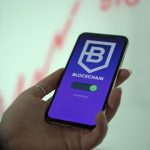 Mão segurando um smartphone com uma carteira digital de criptomoedas exibida na tela.