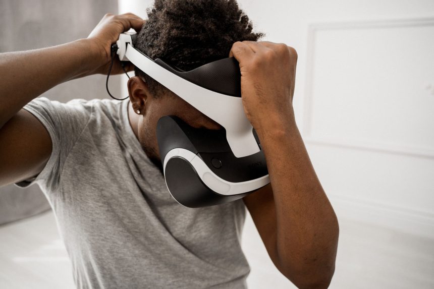 Homem ajusta um headset de realidade virtual em um ambiente interno bem iluminado.
