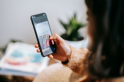Pessoa mostra no celular uma imagem de peças de vestuário durante uma busca visual em ambiente doméstico.